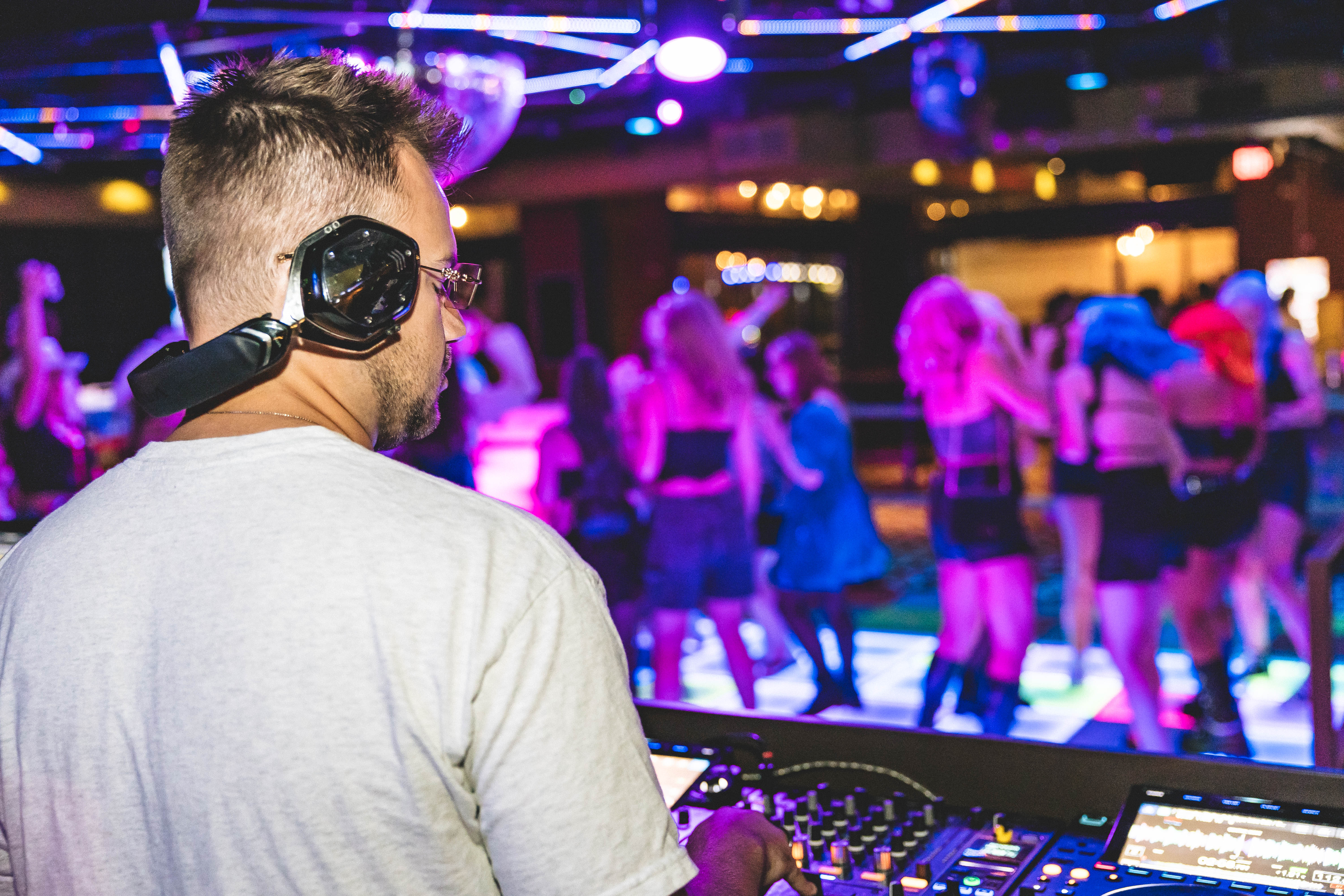 Logan DJing a packed Columbus club dance floor with colorful lighting